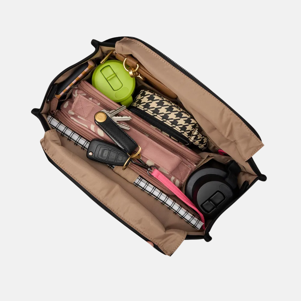 Open bag with various items including a green bottle, keys, and a phone on a light gray background