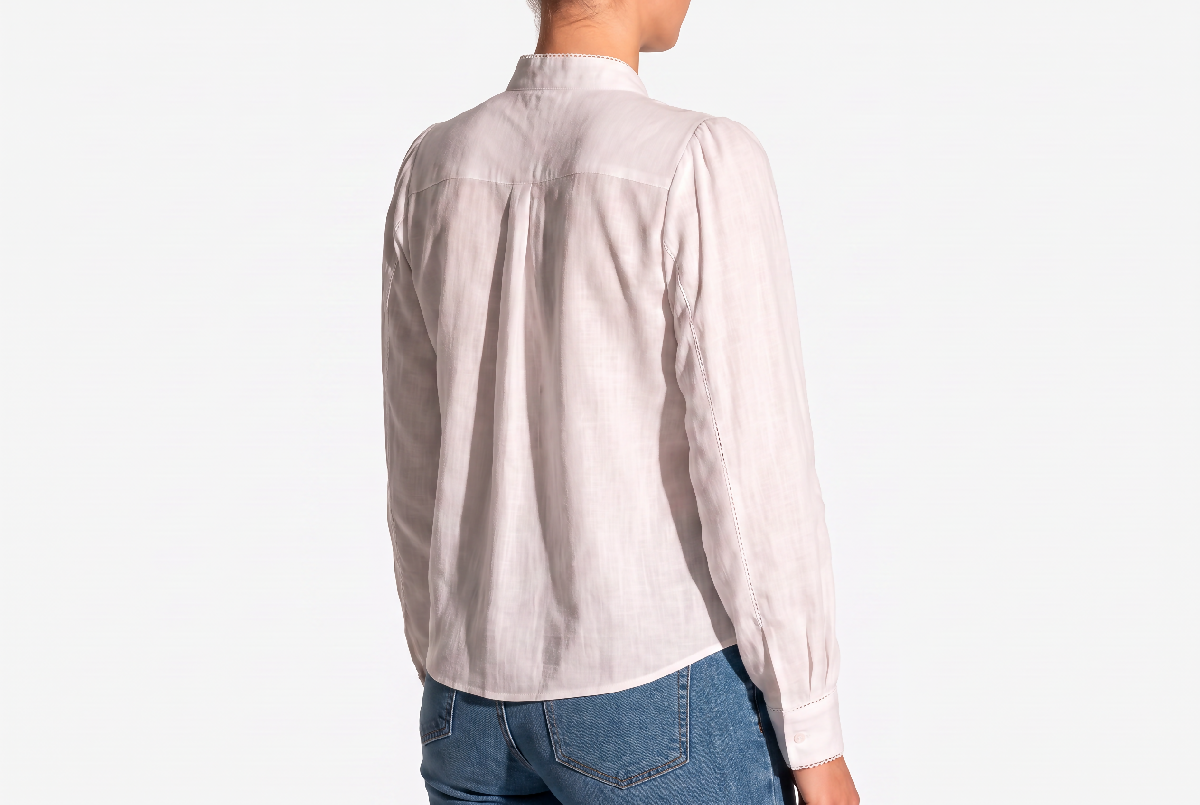 Generated with Kive.ai - Recompose Image 1 as a refined editorial three-quarter back view_ angled slightly to reveal the blouse's back and a small portion of the jeans worn below the 